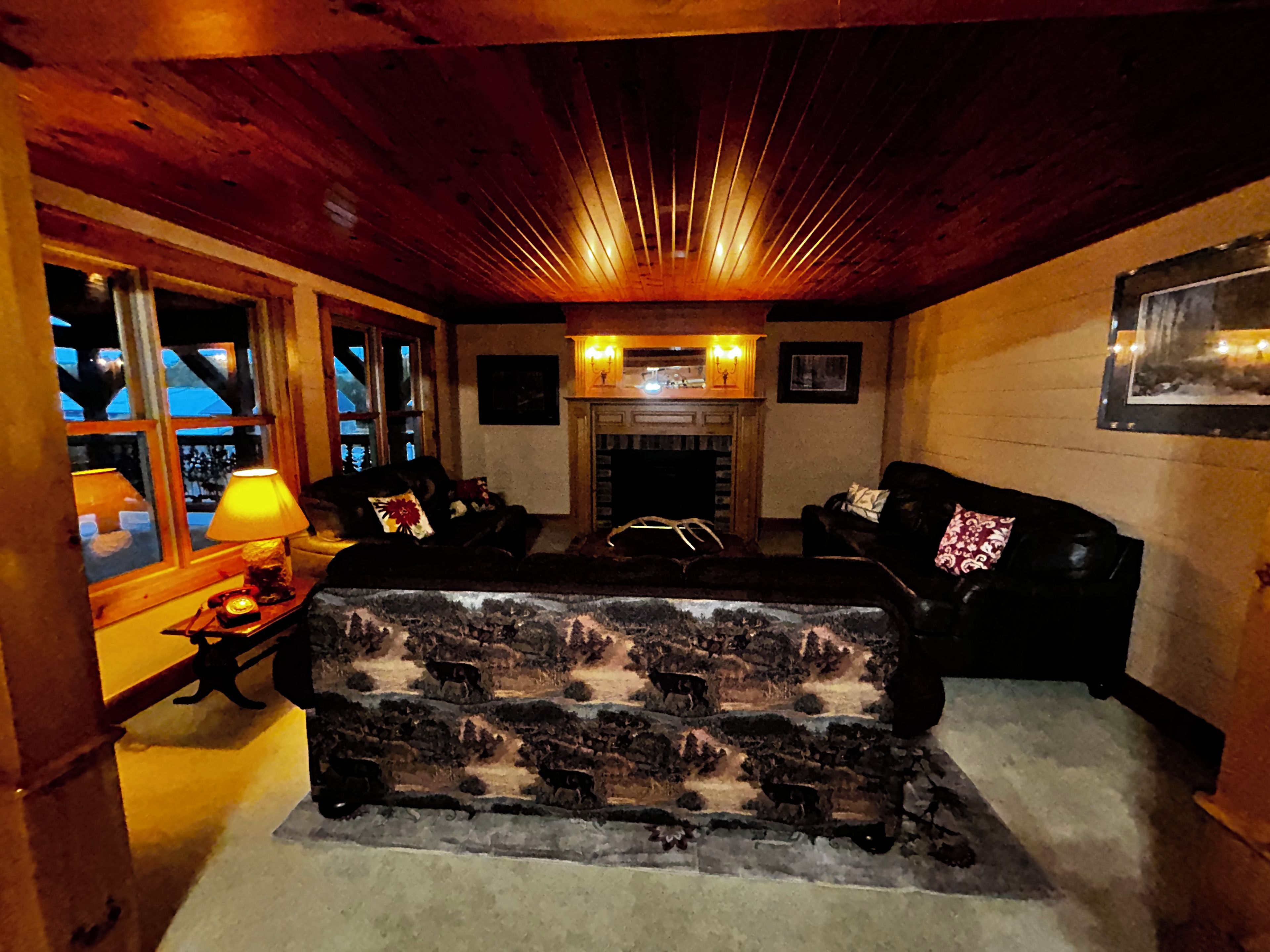 A cozy living room with a fireplace, a sofa, and a lamp.