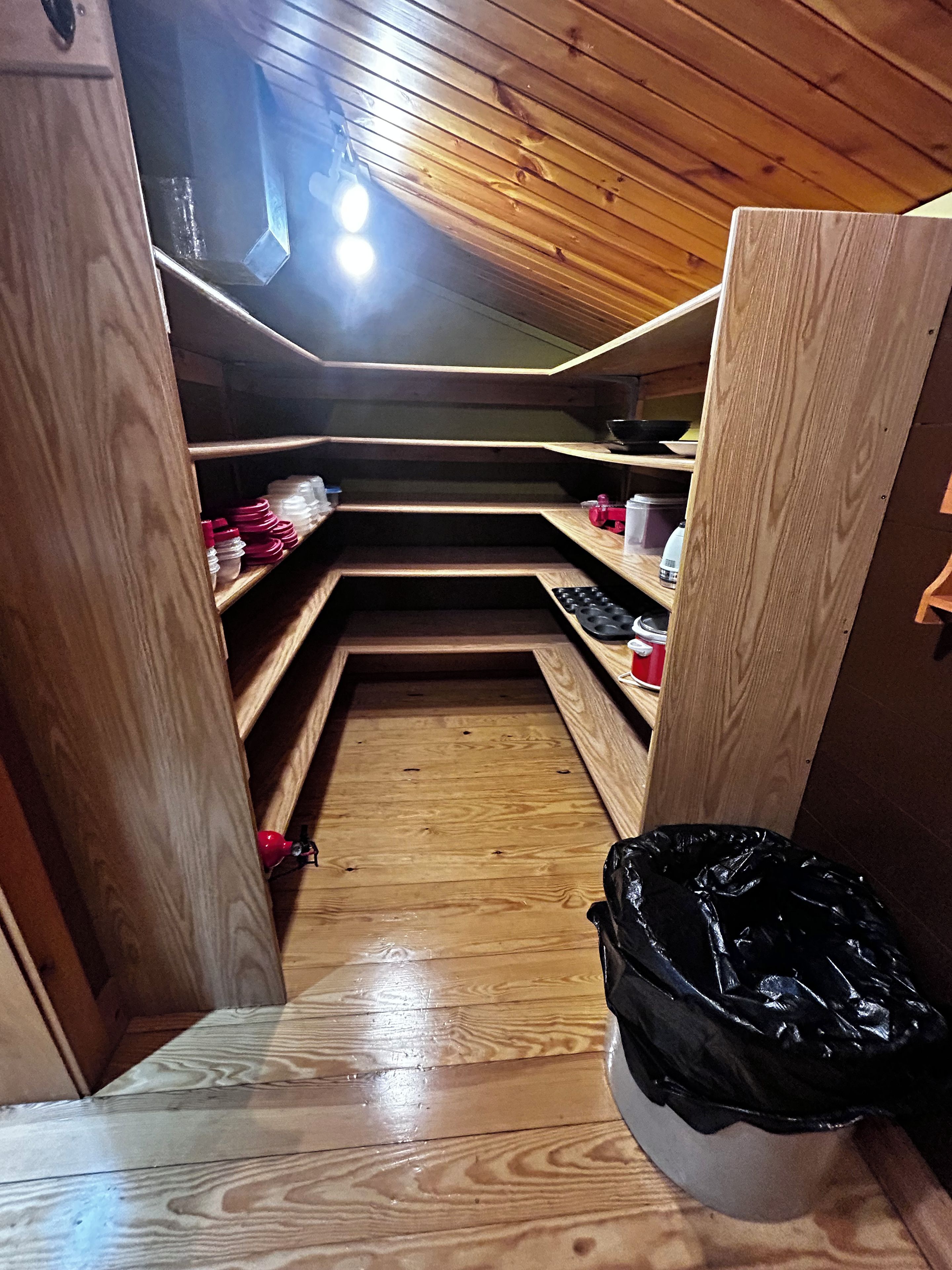 A wooden interior with a built-in bench and shelves.