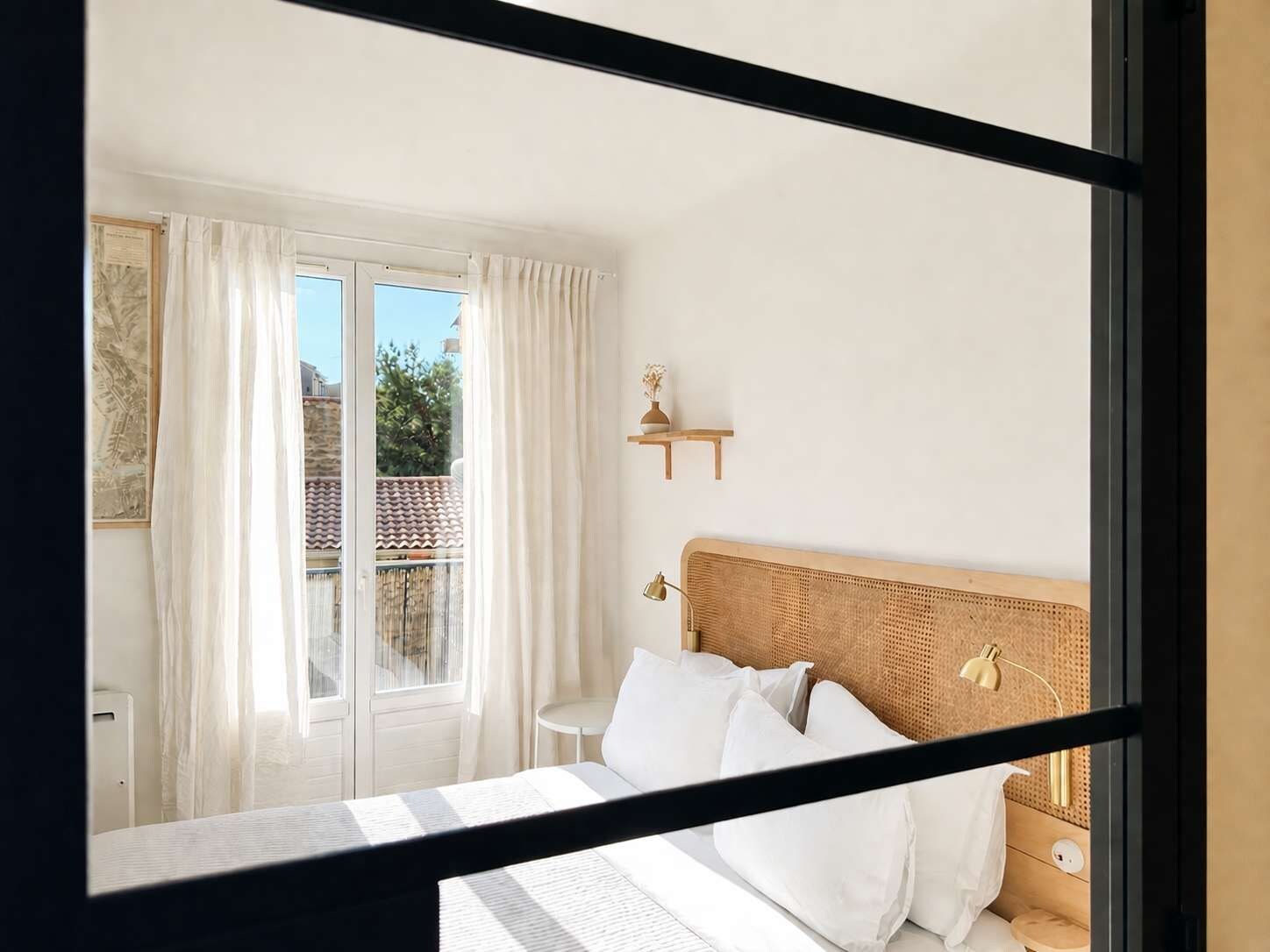 Ein Schlafzimmer mit einem Bett, einem Nachttisch, einer Lampe und einem Fenster mit Vorhängen.