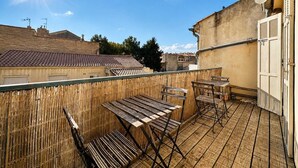 A balcony with wooden furniture and a view of neighboring buildings. - Ersextius, LMR1, Aix-en-Provence (Aix-en-Provence)