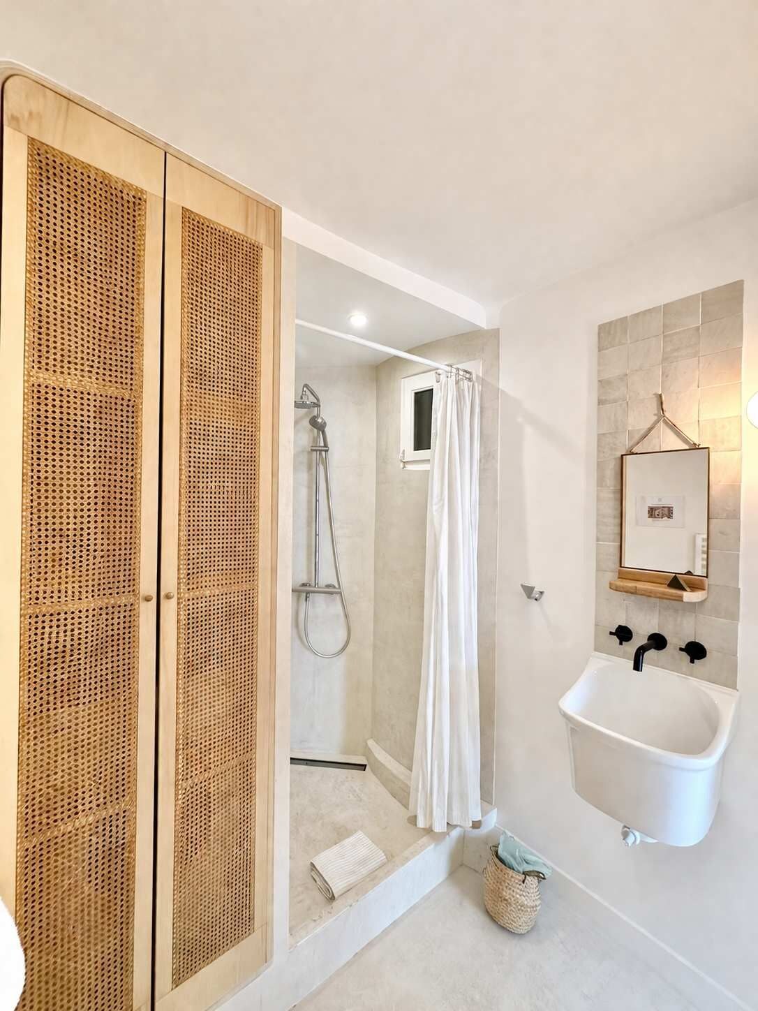 Ein Badezimmer mit Dusche, Waschbecken und Spiegel.