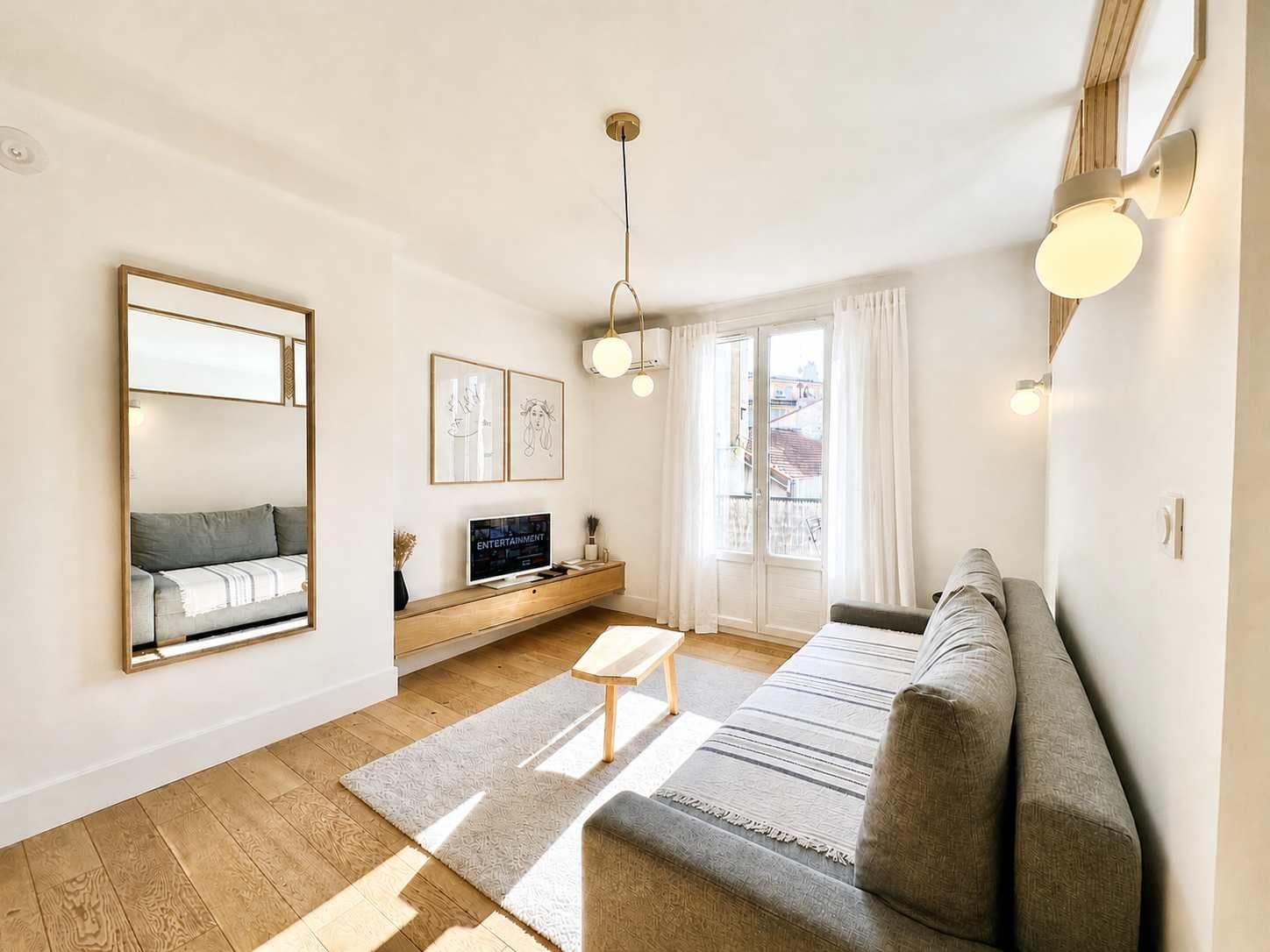 Ein modernes Wohnzimmer mit einer Couch, einem Fernseher und Kunstwerken an der Wand.