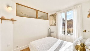 A bedroom with a bed, a window with curtains, a radiator, and a wall-mounted mirror. - Ersextius, LMR1, Aix-en-Provence (Aix-en-Provence)