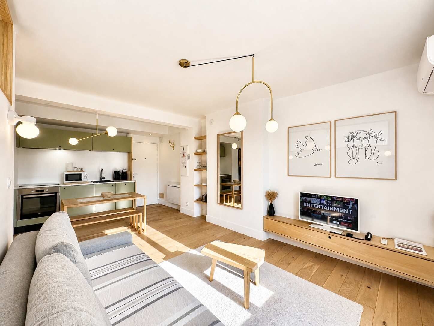 Ein modernes Wohnzimmer mit einer Couch, einem Couchtisch und einem Fernseher auf einem Holzboden.