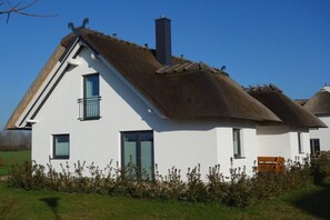 A white house with a thatched roof and a chimney. - Holiday home with 3 bedrooms (Poseritz OT Mellnitz-Hof)