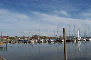 Ein Yachthafen mit vertäuten Booten, ruhigem Wasser und blauem Himmel.