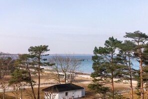 A coastal property with a small cabin, a pier extending into the water, and a beach area. - Beach bliss at the Baltic Sea House (Binz)