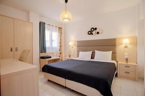 Una camera da letto moderna con un letto grande, comodini, un armadio e una lampada a sospensione.