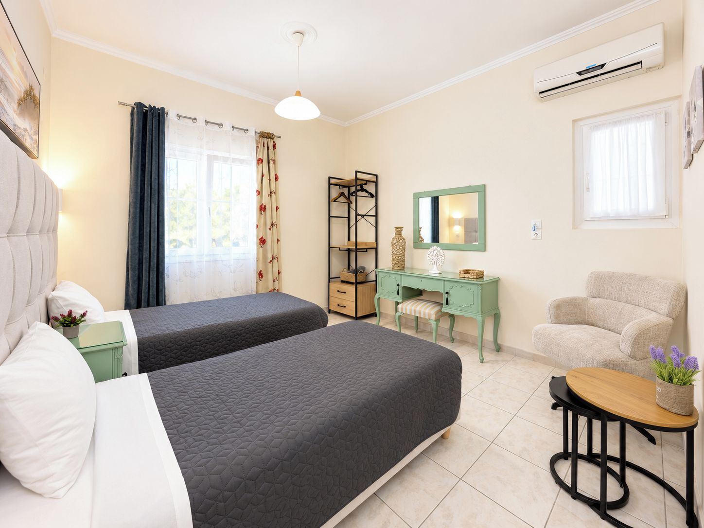Une chambre d’hôtel avec deux lits, un bureau, une chaise et une petite table.