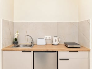 Una cocina moderna con salpicadero de mármol, electrodomésticos de acero inoxidable y encimera de madera.