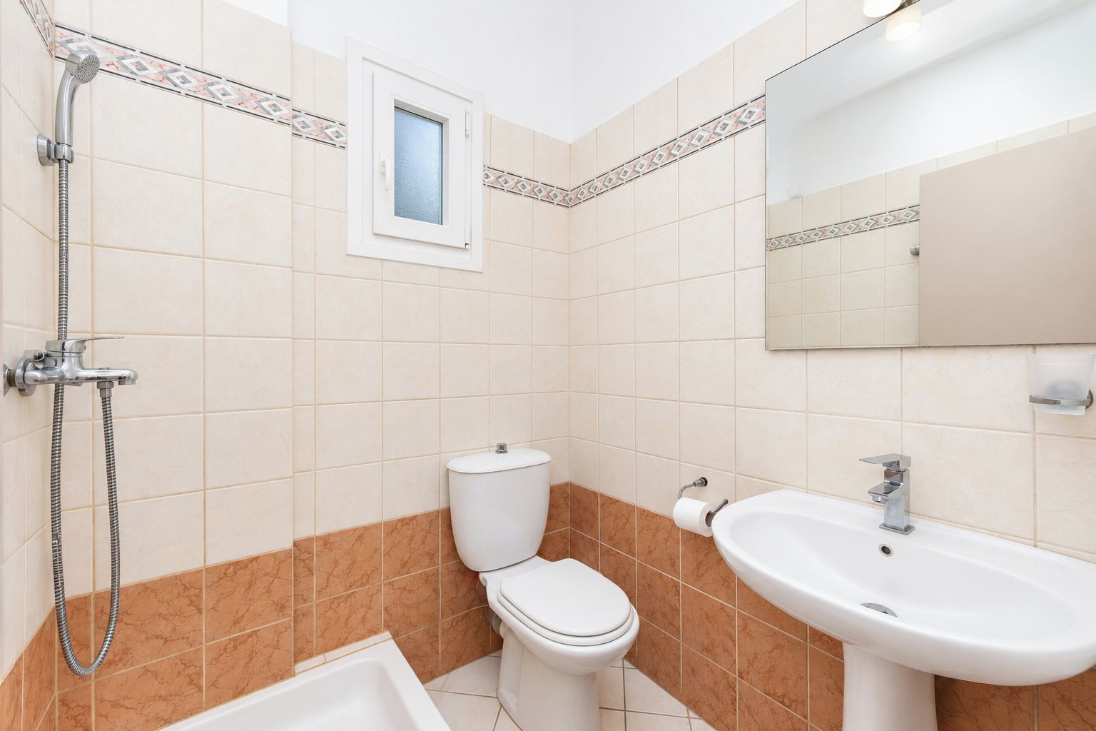 Une salle de bain avec une douche, des toilettes, un lavabo et une fenêtre.