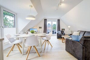 Un espacio habitable moderno con comedor, sofá y televisor.