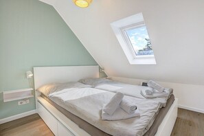 A bedroom with a bed, a window, and a light fixture. - Holiday apartment with 1 bedroom (St. Peter-Ording)