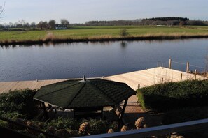 Ein ruhiger See mit einem hölzernen Steg und einem Pavillon.