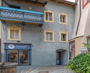 A building with a blue storefront labeled 'Marktcafé' and a small entrance door. - Kehlstein Apartment, 55 square meters, for 2–4 people (Berchtesgaden)
