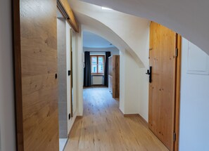 A hallway with wooden doors and a view into a room with a window. - Kehlstein Apartment, 55 square meters, for 2–4 people (Berchtesgaden)