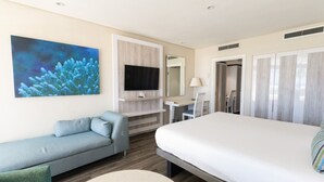 Ein Hotelzimmer mit Bett, Sitzecke, Schreibtisch, Fernseher und Badezimmer.