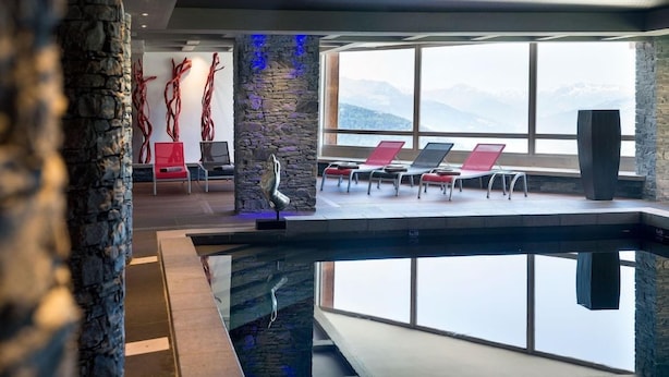 A modern indoor pool area with lounge chairs and a view of mountains. - Cgh Residences & Spas Le Lodge Hemera (Montvalezan)
