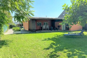 A house with a small patio, a lawn, and a lounge chair. - Holiday home in Ketzin with swimming pool (Ketzin)