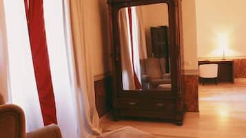 Una stanza con un grande specchio, una poltrona marrone, un poggiapiedi e una sedia.