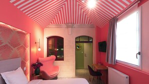 Een slaapkamer met een bed, een stoel, een tafel en een televisie.
