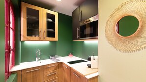 Een keuken met houten kastjes, een roestvrijstalen oven en een bijzondere wandversiering.