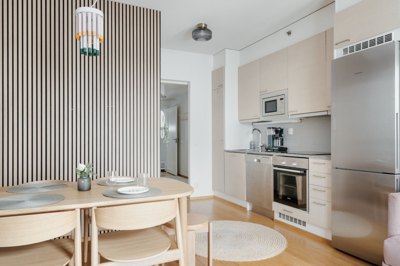 A modern kitchen with a stainless steel refrigerator, microwave, and dishwasher.
