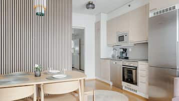 A modern kitchen with a stainless steel refrigerator, microwave, and dishwasher.