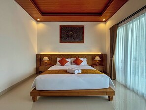 Habitación de hotel con una cama grande, cabecera de madera, dos mesitas de noche con lámparas, un adorno en la pared y vistas al exterior a través de cortinas translúcidas.
