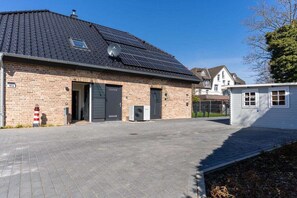 A building with a brick facade, a dark roof, and solar panels. - Holiday home with 2 bedrooms (Kellenhusen)