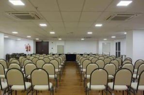 Una sala de conferències amb files de cadires orientades cap a un escenari.