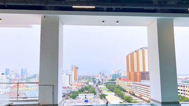 Une piscine intérieure avec vue sur la ville, de grandes colonnes et un sol carrelé.