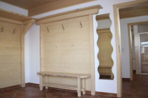 A room with a wooden bench, a wall-mounted coat rack, and a door with a unique wavy design. - Holiday home in Going with swimming pool (Going)