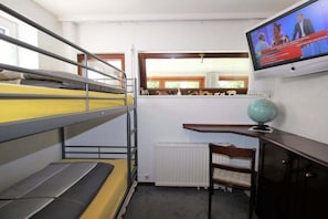 A bunk bed room with a television on the wall, a globe, and a window with a view of trees. - Holiday home with 4 bedrooms (Scharbeutz)
