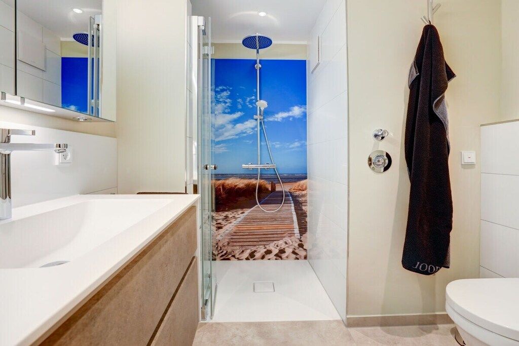 Un bagno moderno con doccia, lavandino e water.