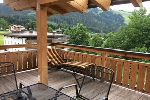 A wooden deck with outdoor furniture, overlooking a mountainous landscape. - Cabin with 1 bedroom (Maria Alm - Hinterthal)