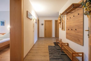 A hallway with a wooden bench, a wall-mounted rack, and a door. - Country house - Praxmarer (Neustift im Stubaital)