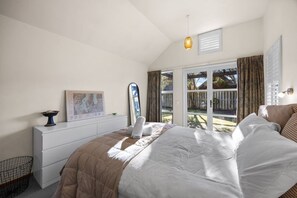 Ein Schlafzimmer mit einem großen Bett, einem Schminktisch, einer Karte und einem Fenster mit Vorhängen.