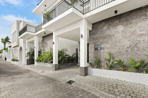 Entrada de un hotel de diseño moderno, con fachada de concreto y un letrero que dice 'ALLENA 2'.