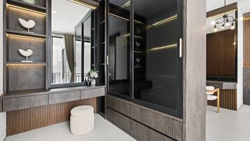 Un baño moderno con un espejo grande, paneles de madera y un banco blanco.