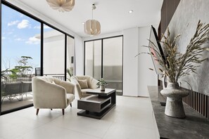 Una sala de estar moderna con un sofá, una mesa de centro y una planta grande en maceta.