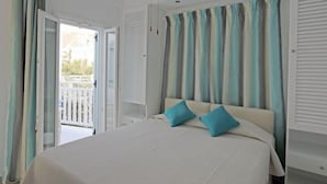 Un dormitorio con cama, cortinas y vistas al exterior.