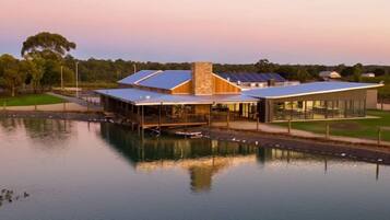 A modern building with a glass facade, a stone chimney, and solar panels.