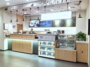 A coffee shop interior with a reception desk, a digital menu board, and a coffee display. - Hanting Hotel Shanghai Songjiang Siting (Shanghai)