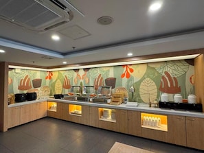 A buffet area with a counter, food containers, and a decorative wall. - Hanting Hotel Shanghai Songjiang Siting (Shanghai)