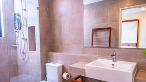 A bathroom with a shower, toilet, sink, and a wooden bench. - Timurbay Seafront Apartment by My Seasons (Kuantan)