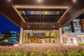 A modern building entrance with a glass facade, a wooden slatted roof, and a slogan above the doors. - Timurbay Seafront Apartment by My Seasons (Kuantan)