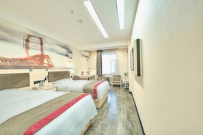 Hotellihuone, jossa on kaksi sänkyä, työpöytä, tuoli, pieni pöytä, televisio ja seinämaalaus, jossa on kuvattuna silta.