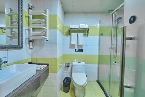 Un baño con lavamanos, inodoro y cabina de ducha de vidrio.