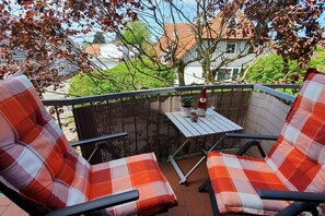 A balcony with two chairs and a small table, surrounded by a bamboo fence. - Electricity View No. 7 (Seeheilbad Zingst)